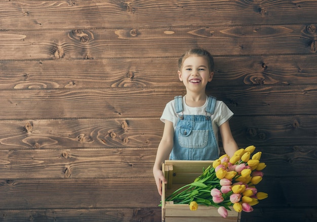 Cute child girl with a bouquet of tulips. Mothers day, spring concept.
