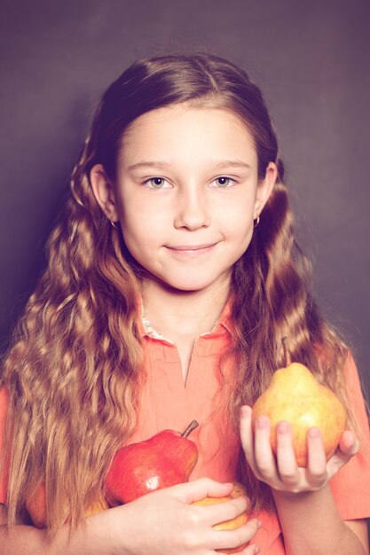 Cute Child Girl with pear fruit. Healthy Eating, food concept