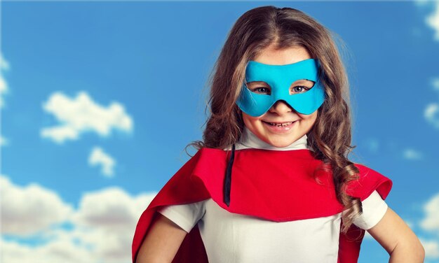 Cute Child in superhero costume on background
