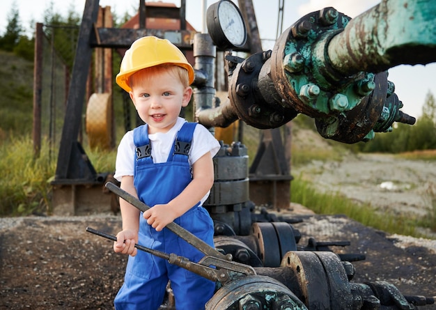 Cute child tightening lug nuts with industrial wrench in oil field