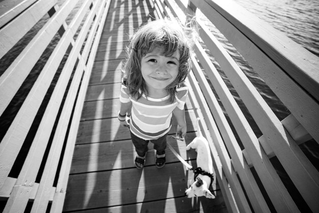 Cute child with puppy dog on walk. Funny smile.