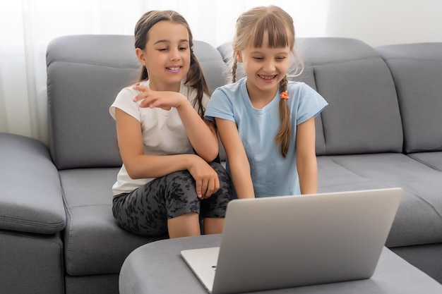 Cute children doing homework with laptop.