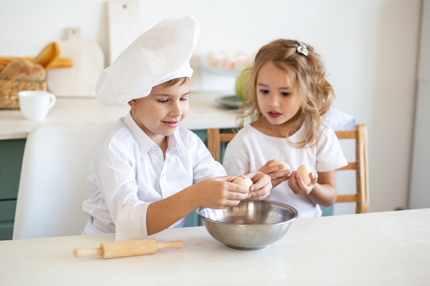 Cute children in the kitchen prepare food at home