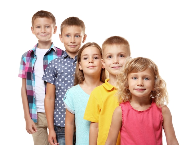 Foto bambini carini in piedi in fila su sfondo bianco