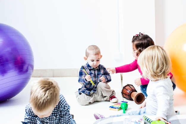 Cute children study musical instruments in the kindergarten