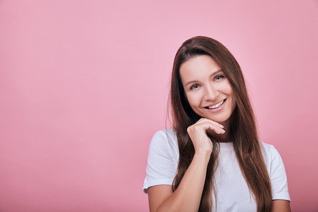 Cute cool woman with brown hair smiles sweetly.