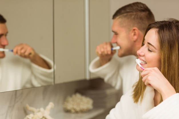 Cute couple brushing their teeth