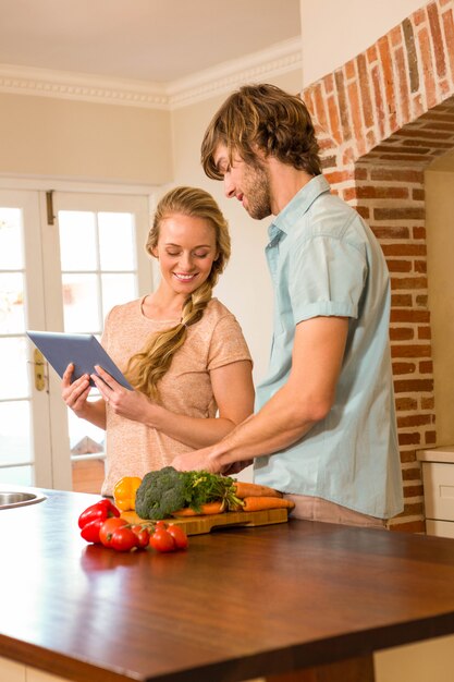 Cute couple cooking and using tablet in the kitchen