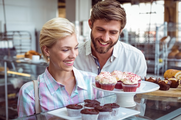 Cute couple on a date looking at cakes 