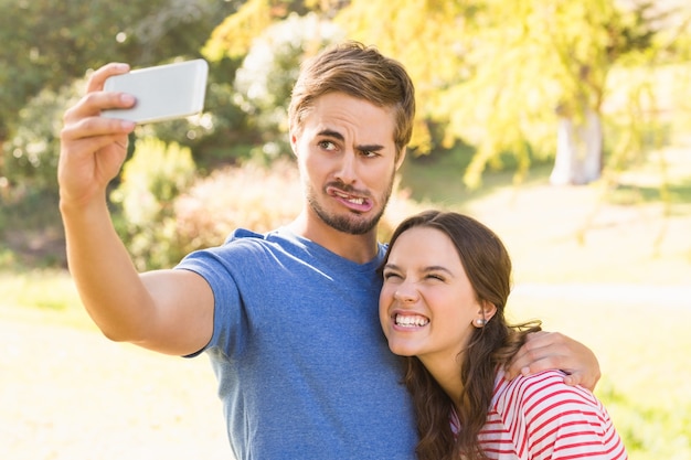 Cute couple doing selfie in the park