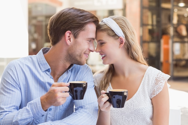 一緒にコーヒーを飲むかわいいカップル