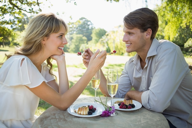 Cute couple feeding each other dessert