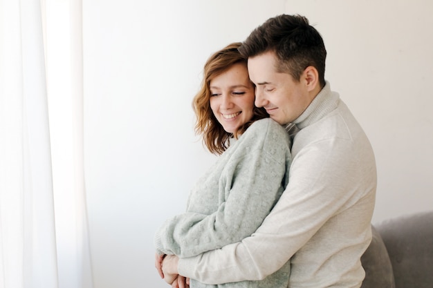 Cute couple hugging and smiling in their home