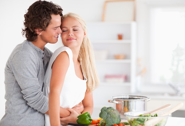 Cute couple hugging while cooking