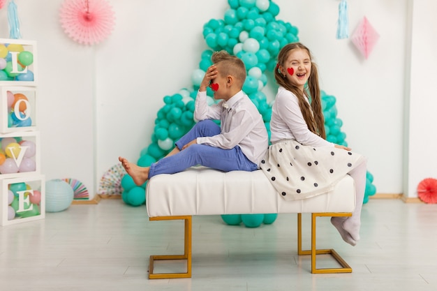 Cute couple of kids with balloons. Valentine's Day and love concept, studio shot