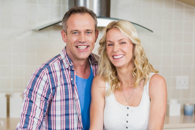 Cute couple looking at camera in the kitchen