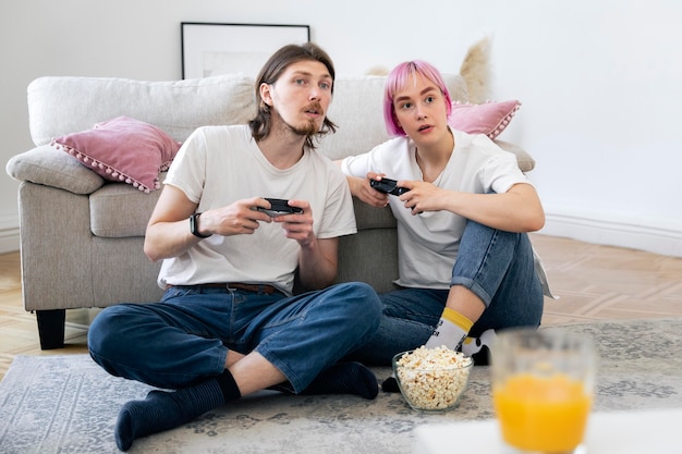 写真 家で一緒にビデオゲームをしているかわいいカップル