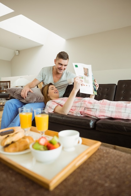 Cute couple relaxing on couch at breakfast