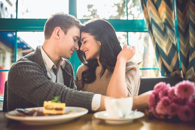 The cute couple sit in the restaurant