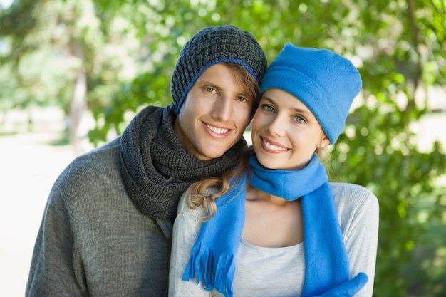 Cute couple smiling at camera in hats and scarves