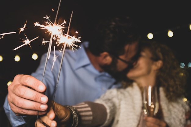 Foto una bella coppia di due adulti innamorati che si danno una perdita insieme la notte di capodanno giocando