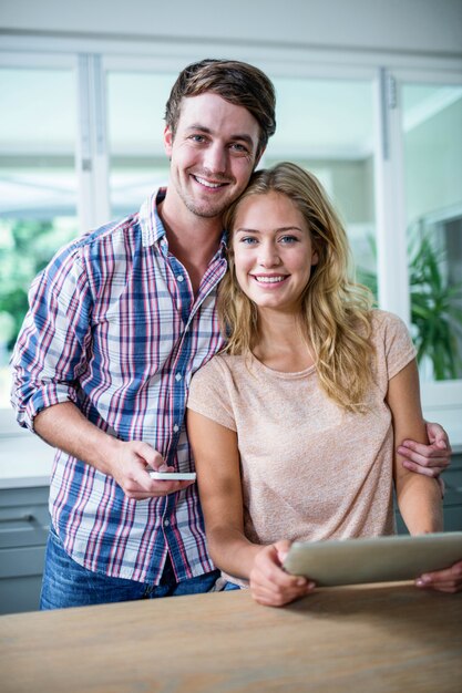 Cute couple using tablet computer in the kitchen at home