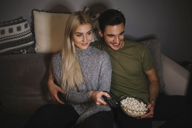 Cute couple watching TV on couch