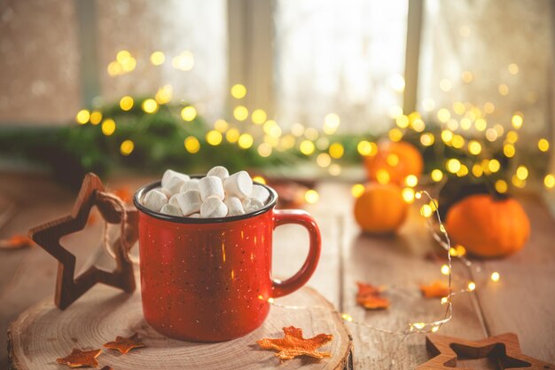 Cute cozy winter composition red mug marshmallows oranges and Christmas lights