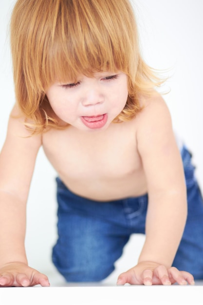 写真 好奇心旺盛で甘い子供の発達のために、床で赤ちゃんと一緒にかわいいハイハイと学習をします無邪気または活発な子供時代のために、スタジオで地面に若い幼児と一緒に若さと健康を成長させ、愛らしいです