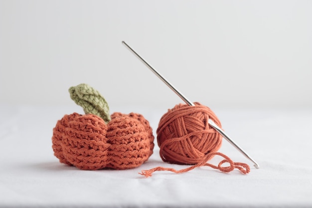 Cute crochet knitted orange pumpkin on white background