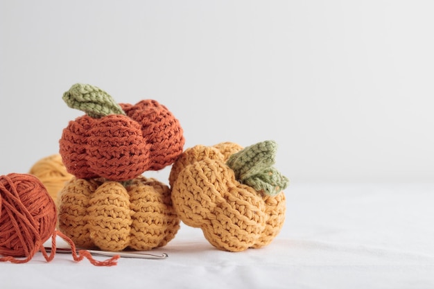 Cute crochet knitted yellow and orange pumpkins on white background