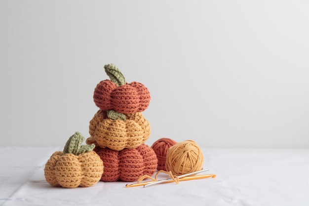 Cute crochet knitted yellow and orange pumpkins on white background