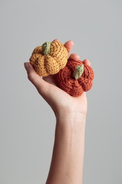 Cute crochet knitted yellow and orange pumpkins on white background