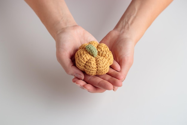 Cute crochet knitted yellow pumpkin on white background