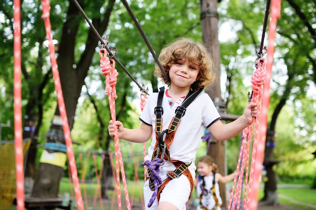 Carino bambino riccio in un parco di corda