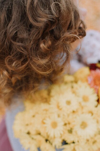 cute curly little girl in blue shirt in park with flowers at fall time autumn health card banner