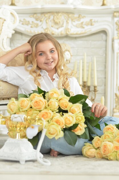 Cute curly teen girl posing with bouquet of yellow roses