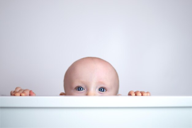 Cute cute baby peeking out on white background