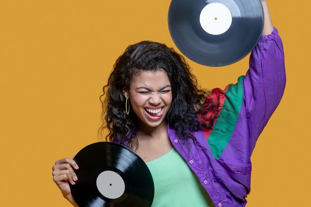 Cute dark-haired young woman holding records and feeling gorgeous