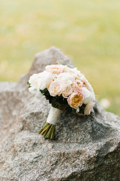 Cute and delicate white peach wedding Bridal bouquet on stone