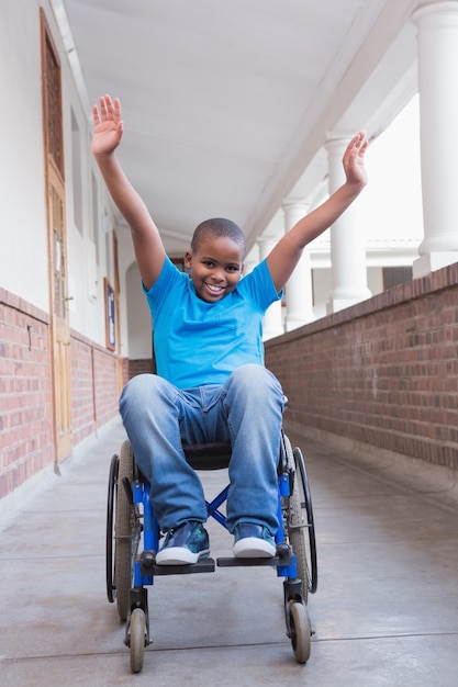 Cute disabled pupil smiling at camera in hall