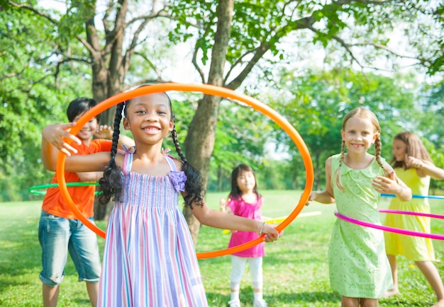 Foto svaghi diversi bambini che giocano con hula hoop