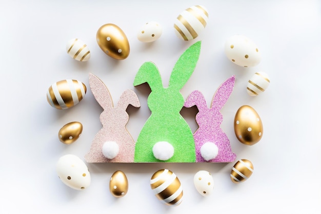 Cute Easter colorful bunnies and golden eggs on a white background Happy Easter minimal concept greeting card soft selective focus