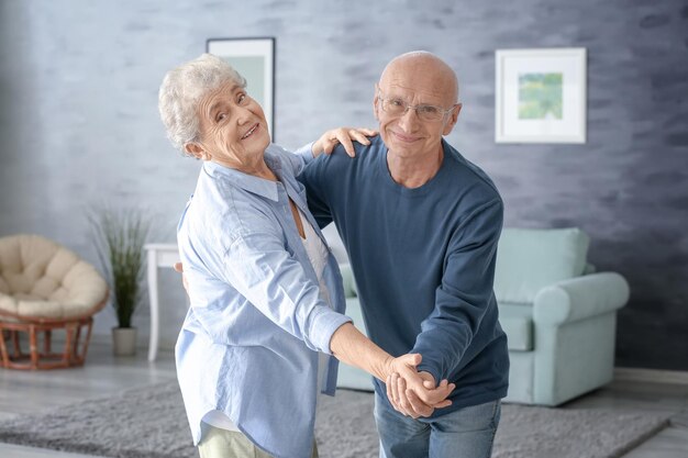 Cute elderly couple dancing at home