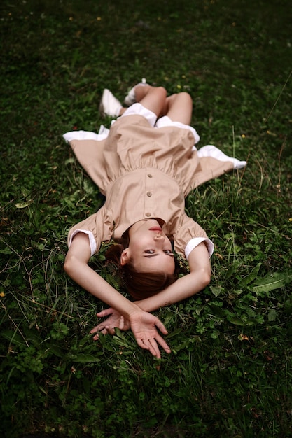 Cute elegant girl lies in the grass