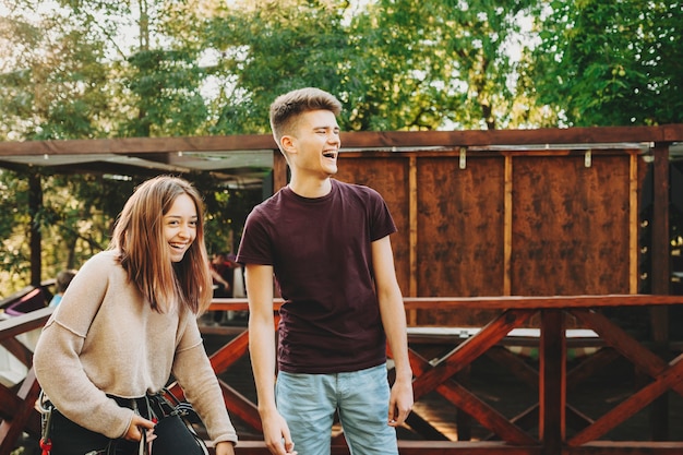 Cute european couple having fun laughing before ropeway where girl is being equipped.