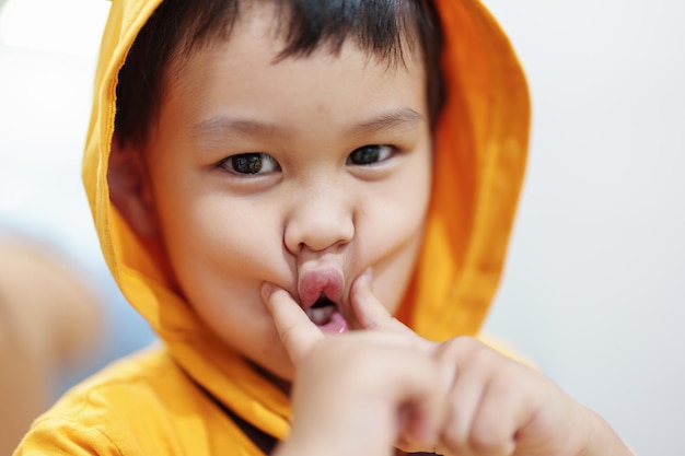 帽子をかぶったアジアの少年のかわいい目は笑顔で無邪気に遊んでいます