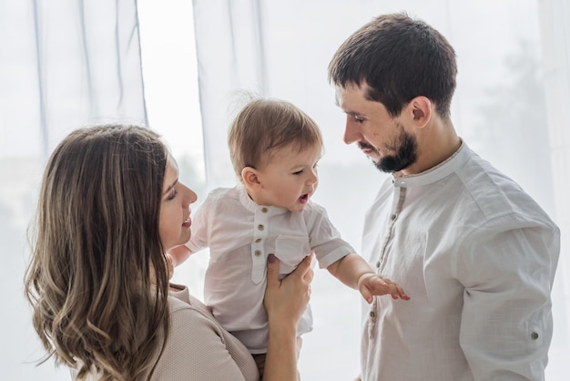 Carina famiglia di padre madre e figlio sorridenti che giocano e scherzano insieme