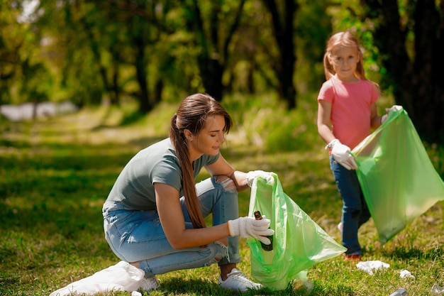 Cute family working in a park gathering garbage