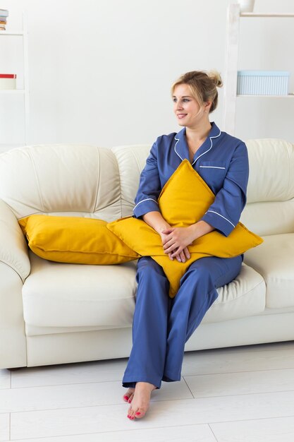 Cute female model in pajama enjoying morning pleasant woman sitting on sofa good mood